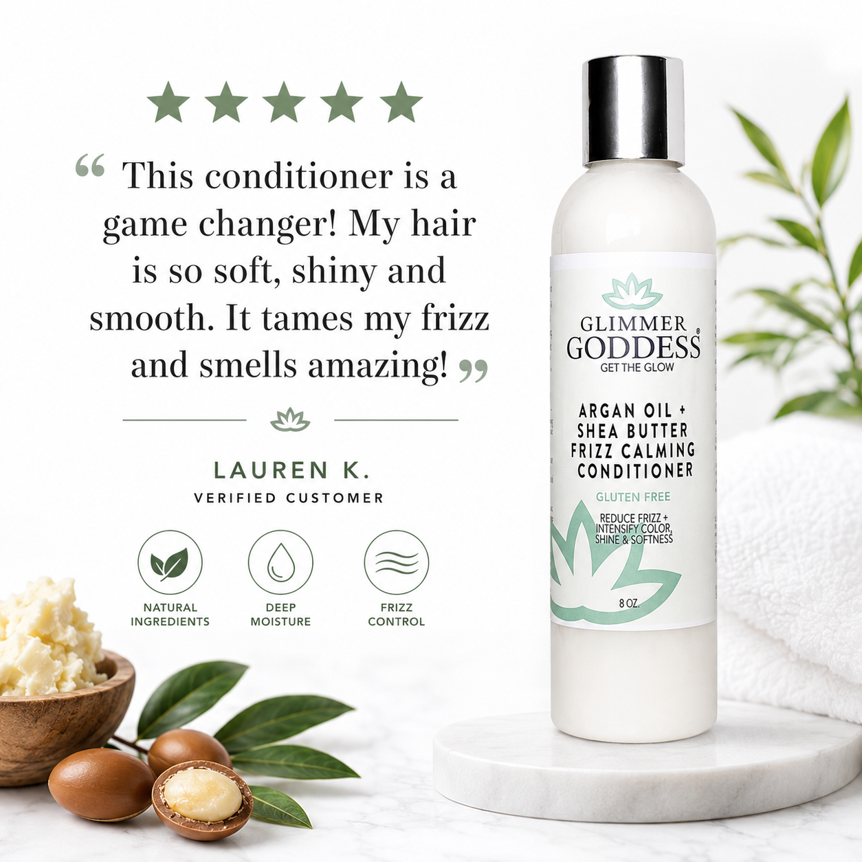 A bottle of Glimmer Goddess Frizz Calming Conditioner displayed on a white marble pedestal, with a customer testimonial, ingredient icons, and argan nuts on a white marble surface.