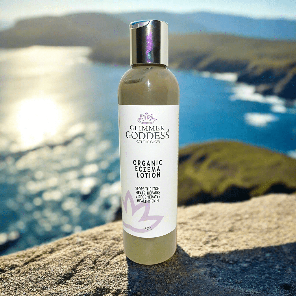 Ocean behind bottle of Organic Eczema Lotion from Glimmer Goddess