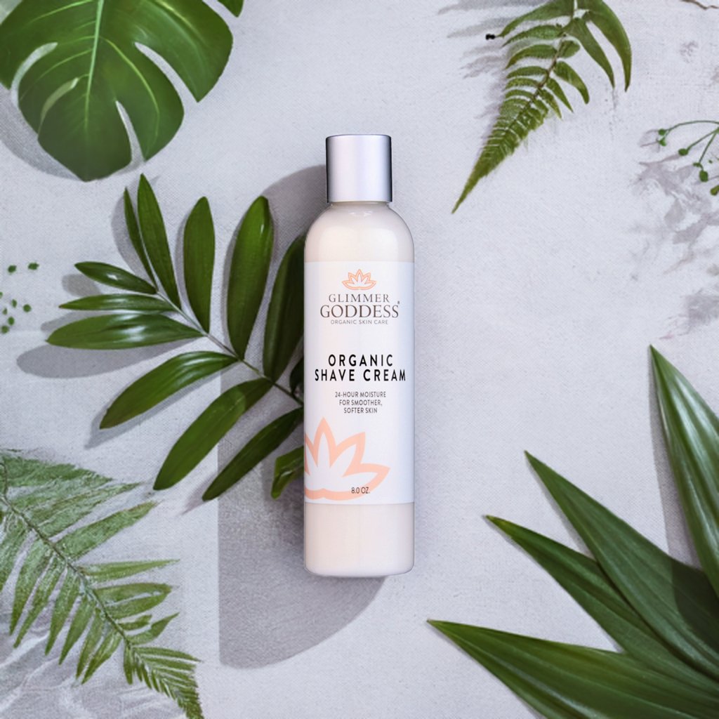 Organic Shave Cream bottle from Glimmer Goddess® surrounded by leaves