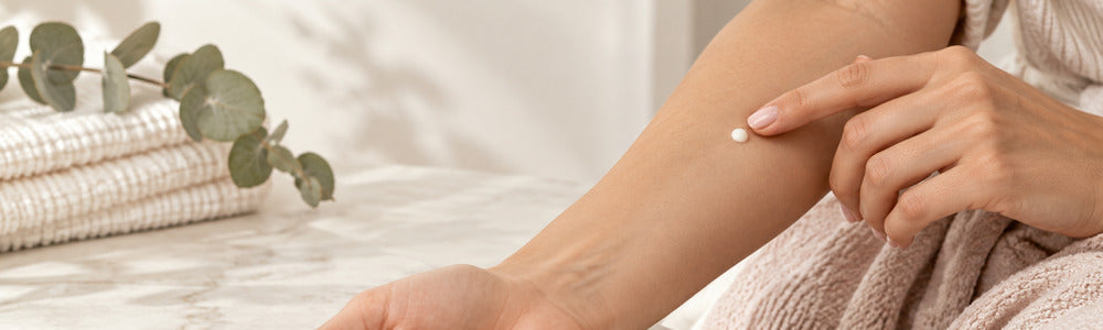 Woman applying a small skincare test dot to her inner forearm
