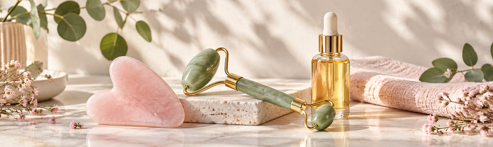 Gua sha stone, facial roller, and massage oil