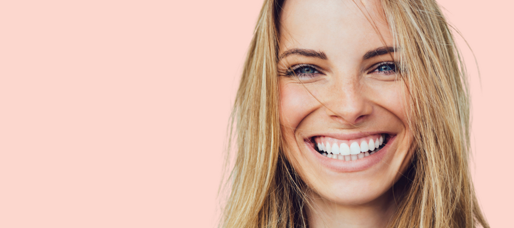 Woman smiling with pink background