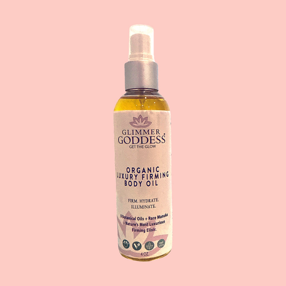 Bottle of Glimmer Goddess organic luxury firming body oil on a pink background