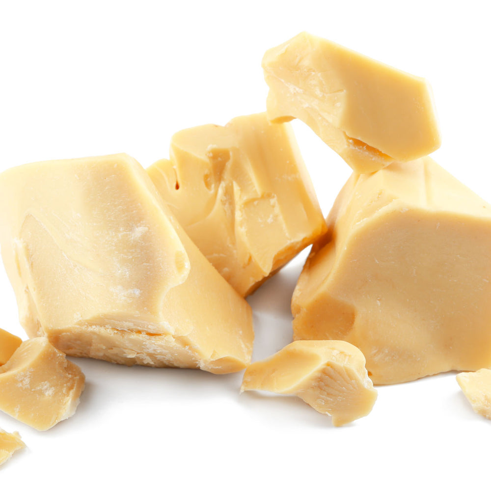 Raw cocoa butter chunks for organic skincare on white background