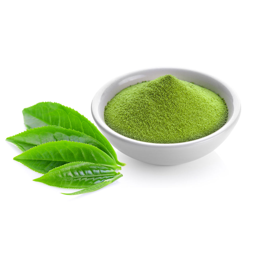 Green tea powder in a white bowl with fresh green tea leaves on white background
