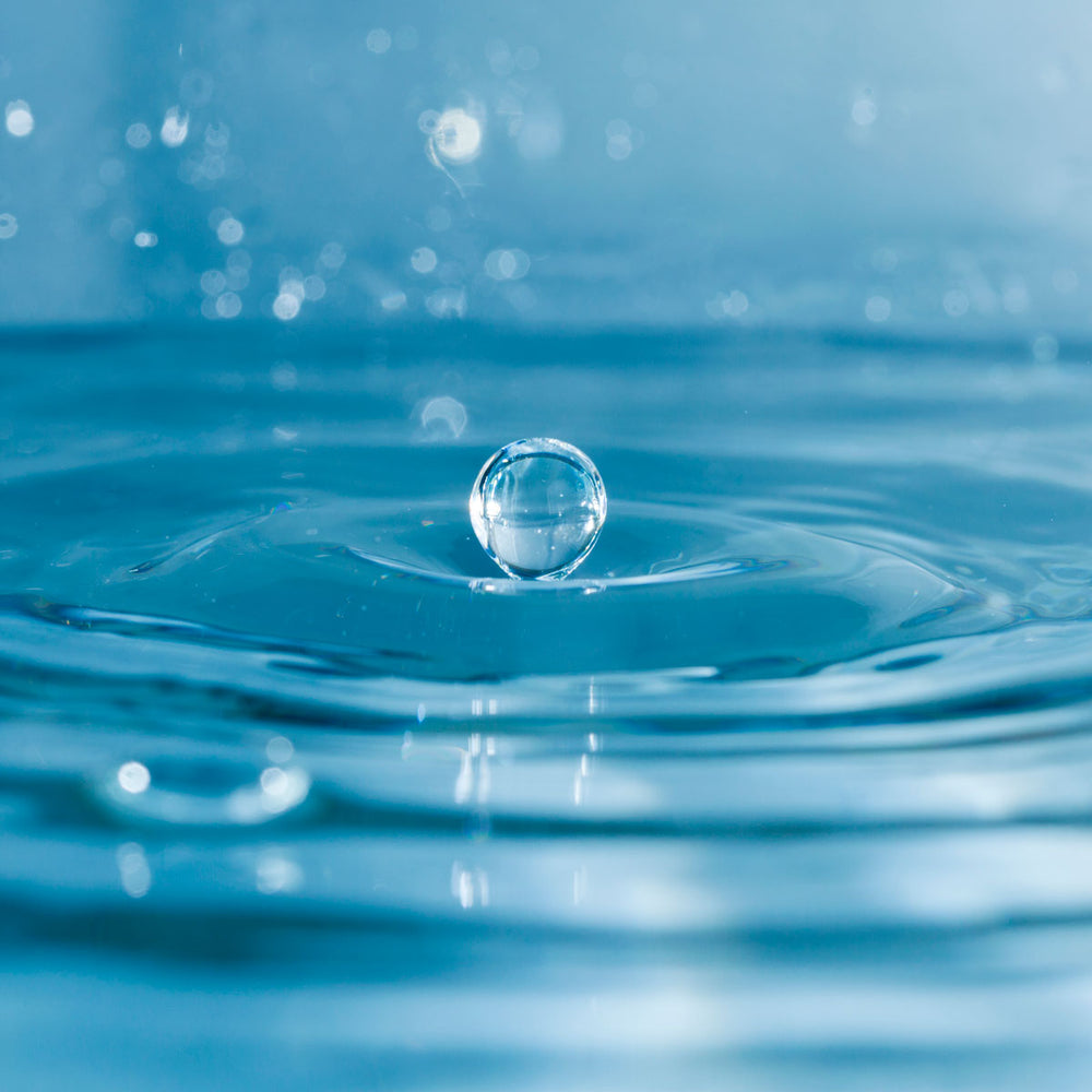 Close-up of water droplet splash symbolizing hyaluronic acid hydration for skin care