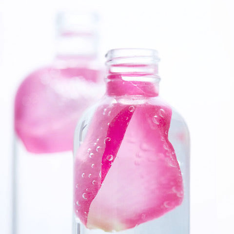 Glass bottle with rose petal in rose water, natural organic skincare ingredient